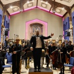 An orchestra standing at the end of a concert
