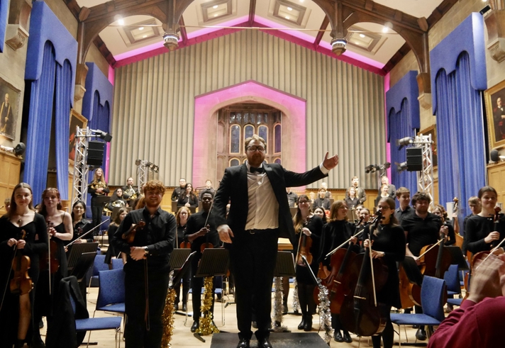 An orchestra standing at the end of a concert