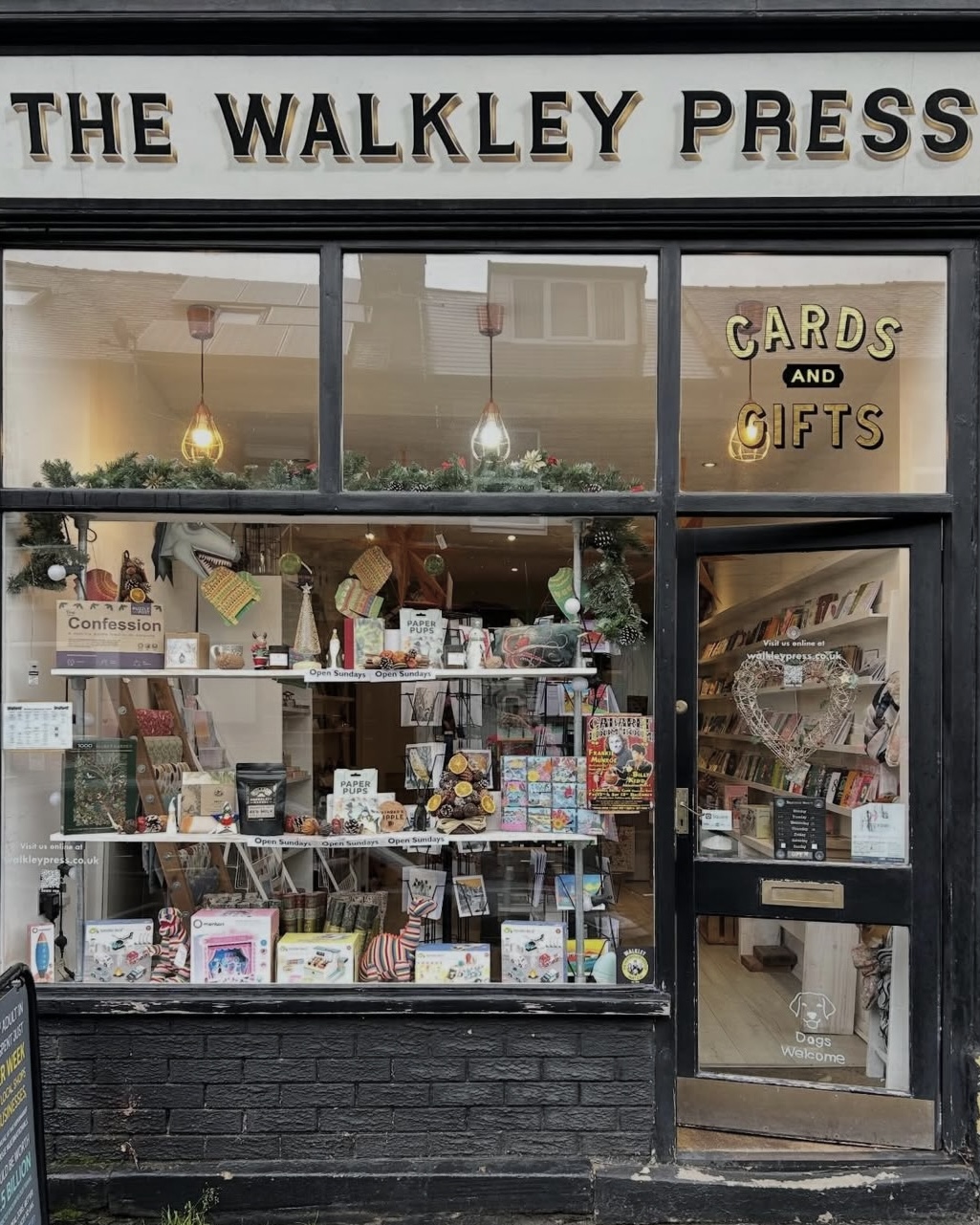 Front window display of The Walkley Press shop, showing cards, gifts, and books arranged inside, with the shop’s name displayed above the entrance.