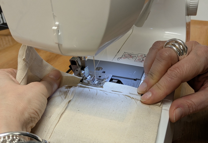 A close-up of someone sewing on a sewing machine.