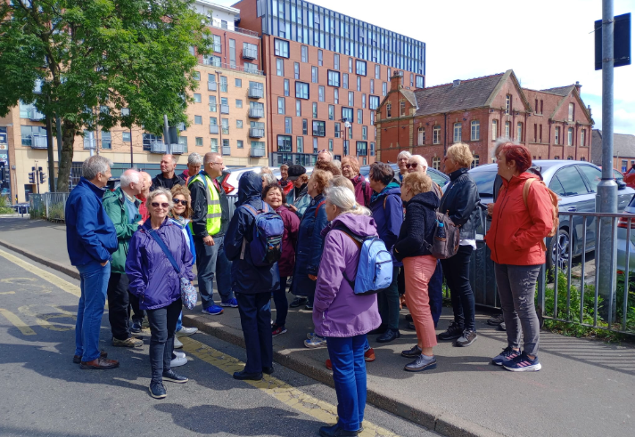 A tour guide talks to a group of people on a tour in Sheffield.