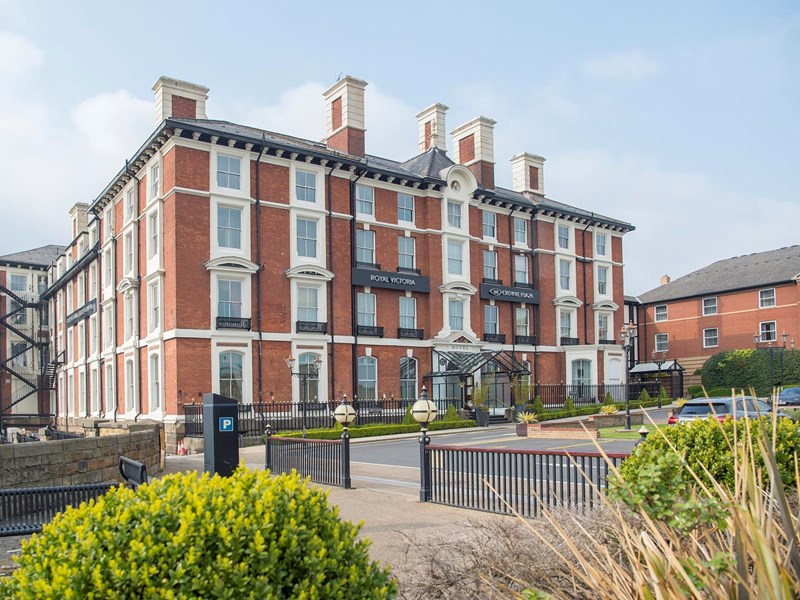 The exterior of the Crowne Plaza Royal Victoria  on a bright sunny day.