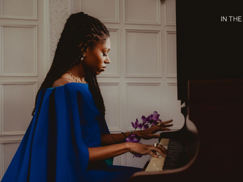 Isata Kanneh-Mason sitting at a piano, playing.