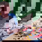 A child sat at a table playing with Lego.