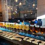 A counter with a long row of glasses of beer.