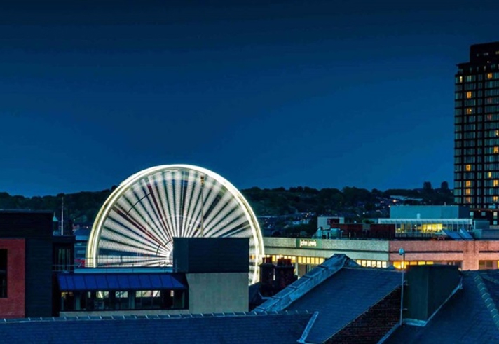The Sheffield skyline at night, with a ferris wheel in the middle of the image.