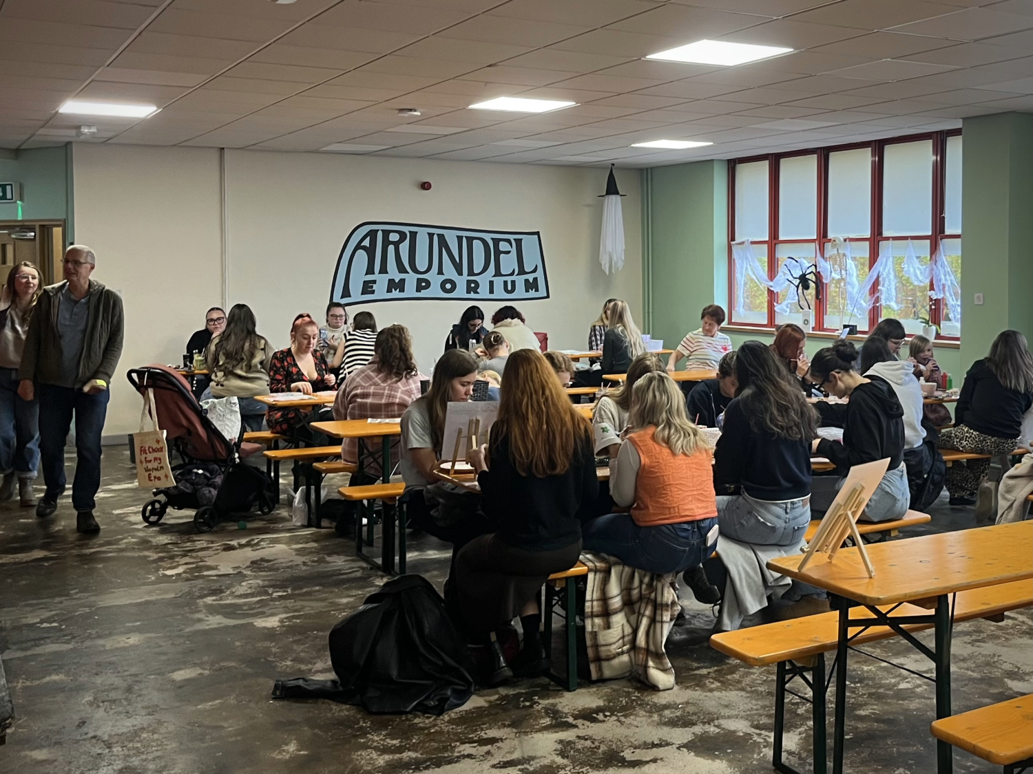 A communal area with tables and benches, full of people.