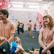People having fun at an indoors climbing wall.