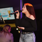 A woman sings into a microphone.