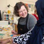 Two people sat at a bench, working together on a printing project.