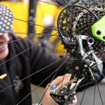 A man servicing the gears on a bike.