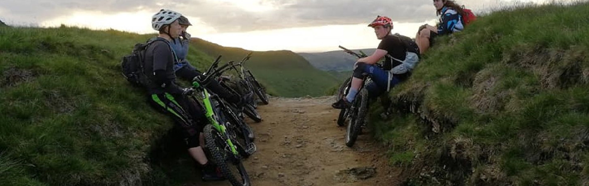 People mountain biking on a dirt track in the countryside.