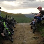 People mountain biking on a dirt track in the countryside.