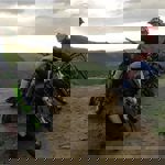 People mountain biking on a dirt track in the countryside.