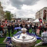 The World Snooker Championship trophy displayed in the foreground with large crowds gathered in Tudor Square and the Crucible Theatre visible behind.