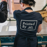 A woman screen printing at Printed by Us.