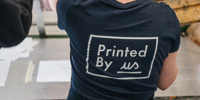 A woman screen printing at Printed by Us.