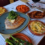 A table set up with meals for 4 people at the Chop Shop Bar & Grill..