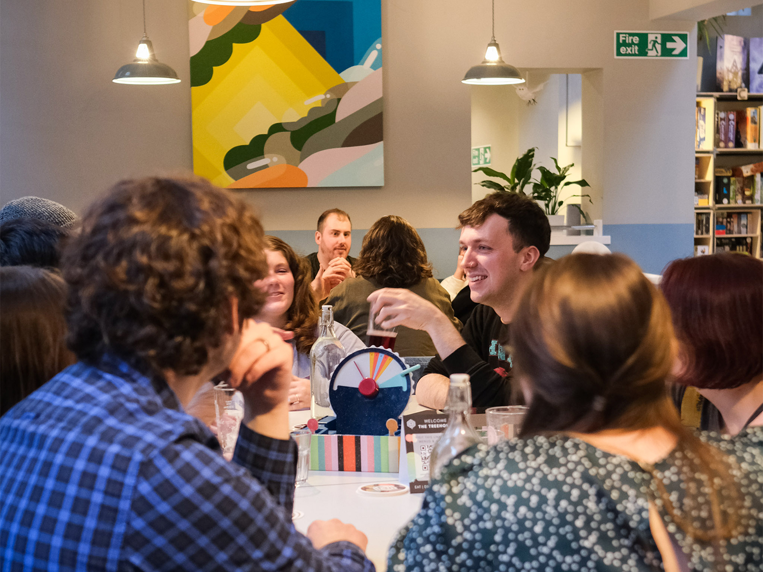Tables at The Treehouse Cafe, filled with people enjoying drinks and playing board games.