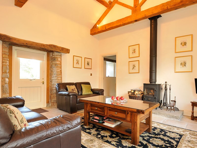Cozy living room featuring a log burner, sofa, and coffee table.