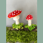Two felted mushrooms on a log.