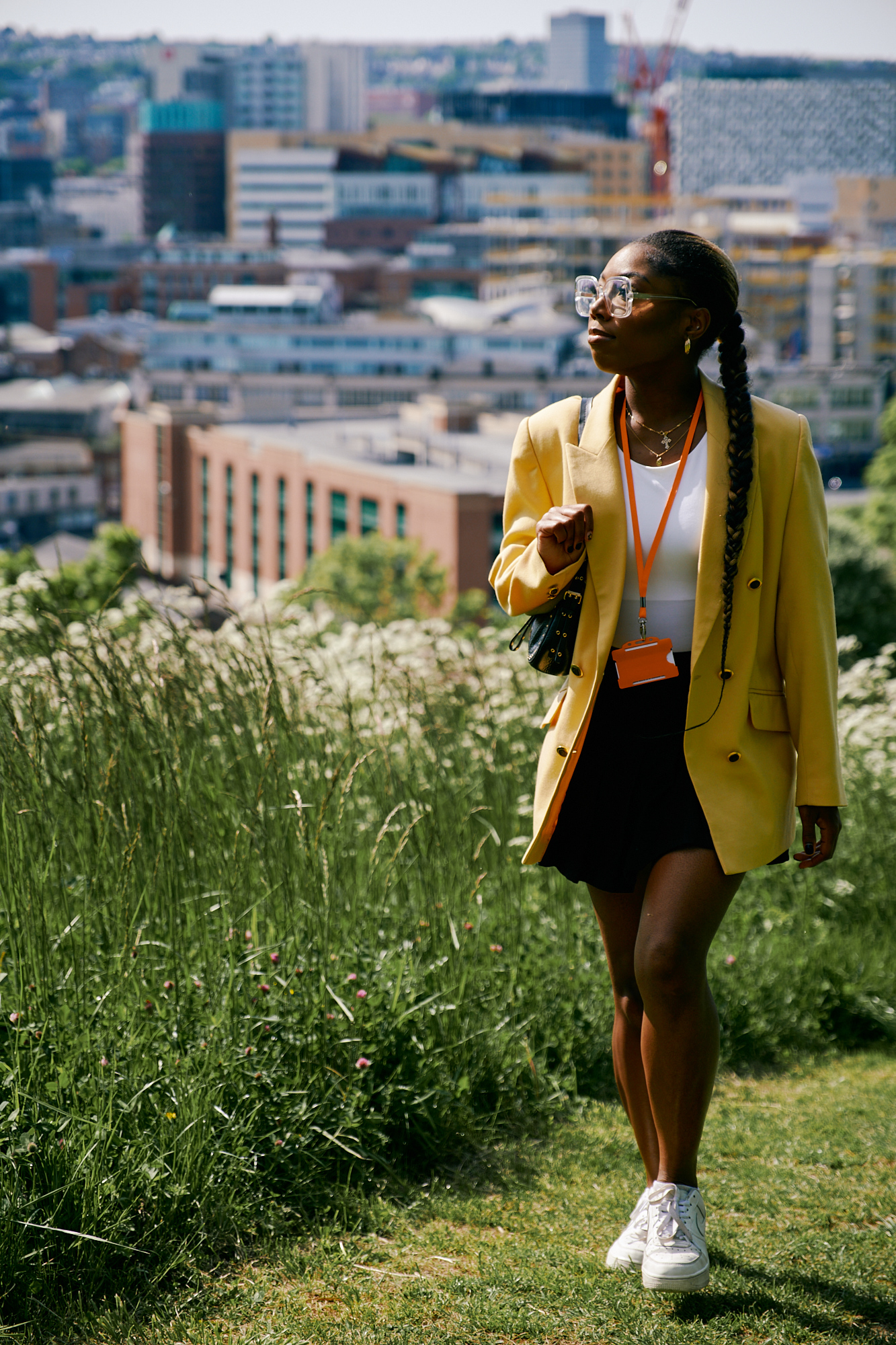 A woman walks through a park, with the Sheffield skyline in the background.