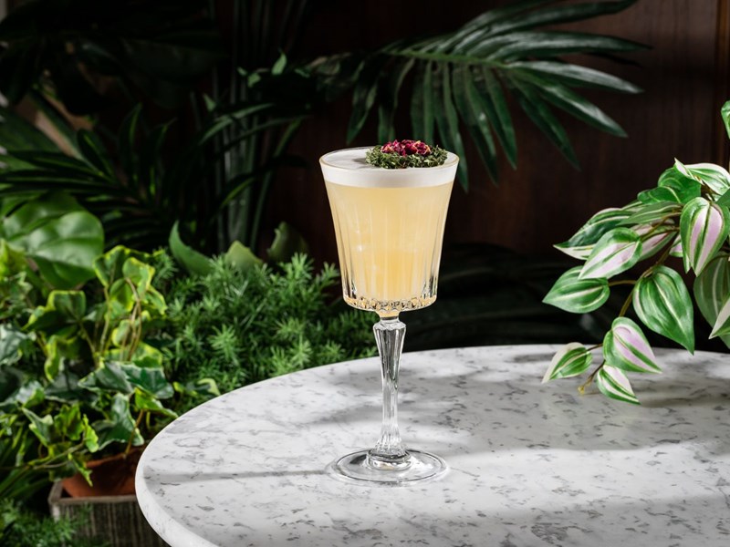 A cocktail sits on a round marble table.