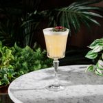 A cocktail sits on a round marble table.