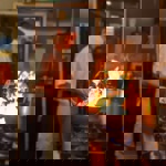 A man cooking with a wok in a kitchen, there are flames leaping from the wok.