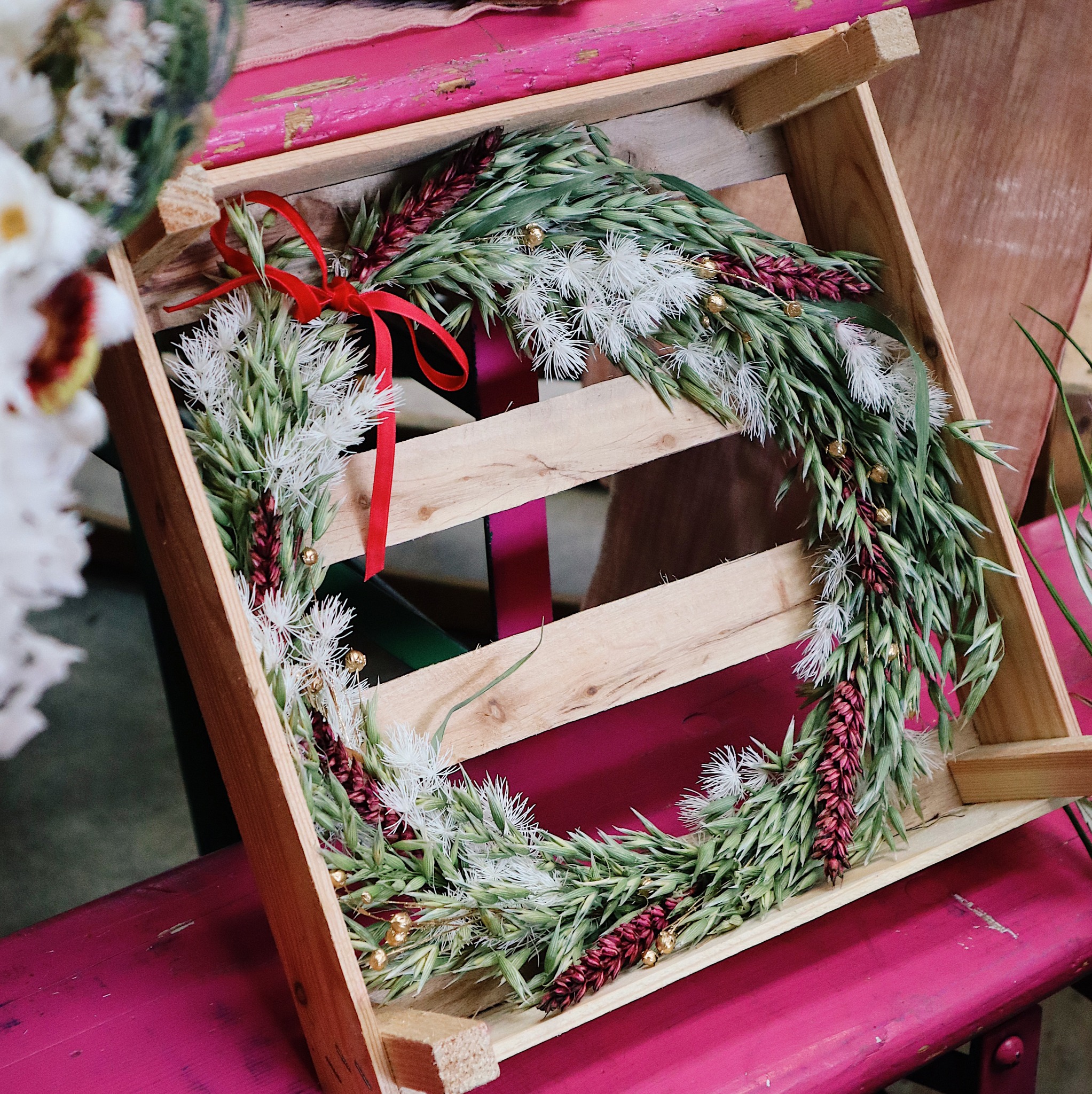 A wooden box with a festive wreath in.