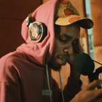 a man in a recording studio, recording vocals.