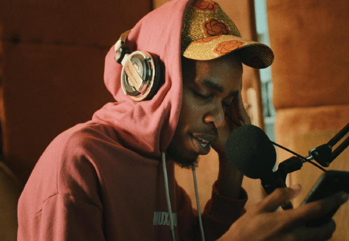a man in a recording studio, recording vocals.