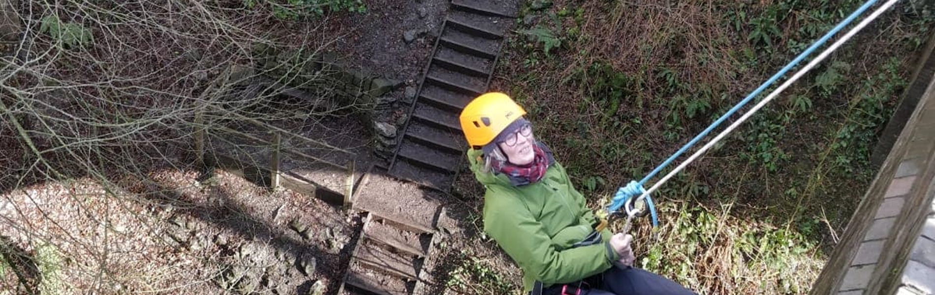 A person abseiling, out in the countryside.