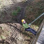 A person abseiling, out in the countryside.