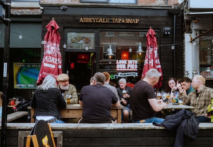 Groups of people sat drinking outside The Abbeydale Tap 