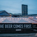 Looking towards the extrovert of Triple Point Brewery at dusk and a big sign that says "the beer comes first"