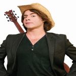 A person in a cowboy hat with a guitar hung across their back.