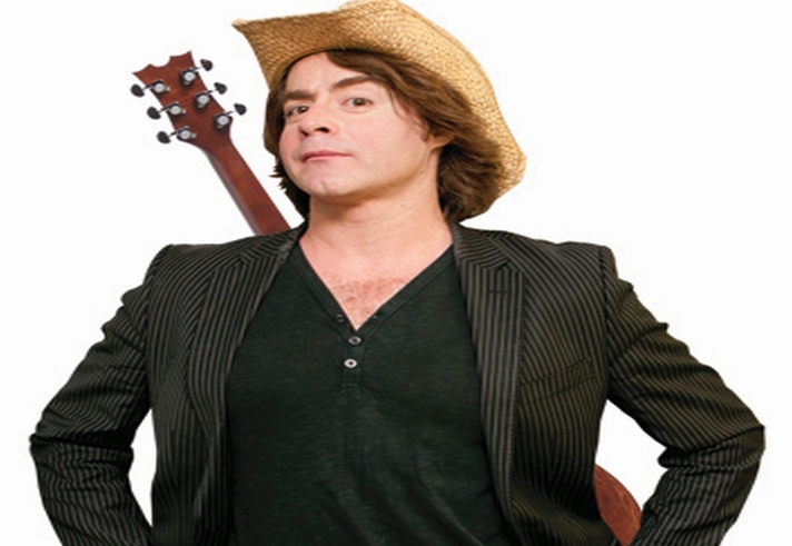 A person in a cowboy hat with a guitar hung across their back.