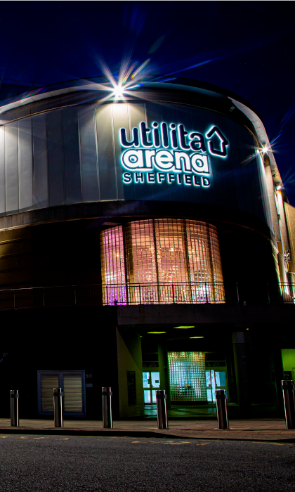 The Utilita Arena Sheffield lit up at night.