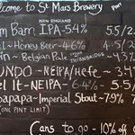 A hand written board with beer names and prices at The Brewery of St Mars of the Desert.