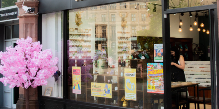 The entrance to Miss Crystal, with a small tree covered in pink blossom to one side.