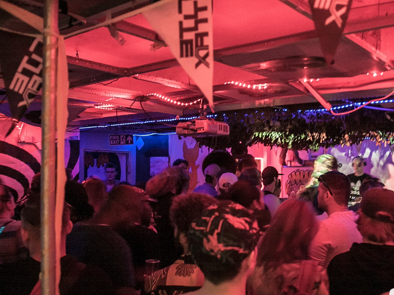 A crowded night club full of people dancing.