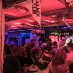 A crowded night club full of people dancing.