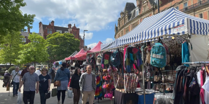 The Sheffield International Market from a previous year. Lots of people are looking around market stalls.