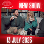 A promo shot of Jon Richardson and Lucy Beaumont sitting on a sofa looking at each other. They are both holding mugs.