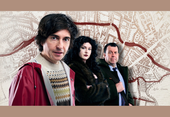 Three people standing in front of an antique map.