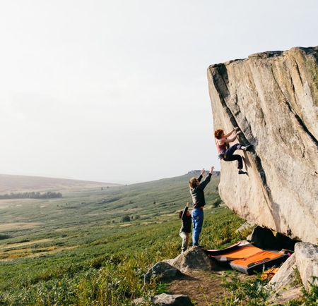 Three people bouldering in the peak district. 