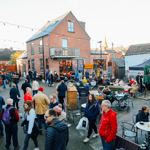 A large crowd of people looking round an outdoor market on Sharrow Vale Road in Sheffield.
