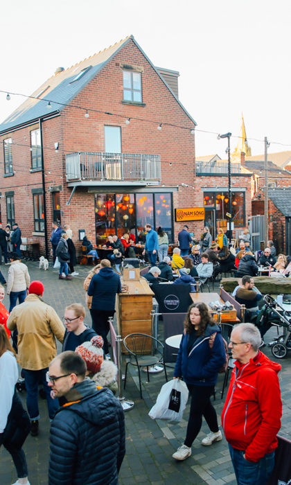 A large crowd of people looking round an outdoor market on Sharrow Vale Road in Sheffield.