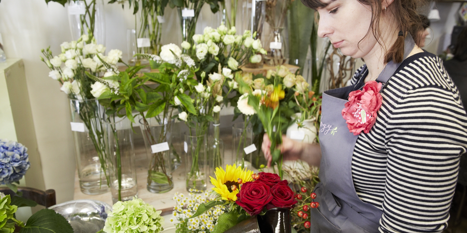 A member of staff arranging flowers at Plantology.